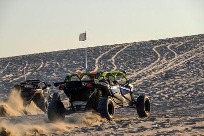 Dune buggies racing over sand dunes in the desert