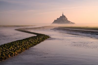 The jagged silhouette of Mont Saint-Michel, Normandy, wreathed in morning mist