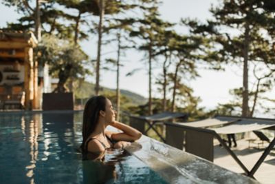 A wellness seeker relaxing in an outdoor pool at a luxury spa resort