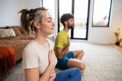 A couple practising mindful breathing, key in a healthy travel routine