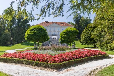 Tivoli Park in Ljubljana, with vibrant flowers beds, leafy trees and a grand mansion