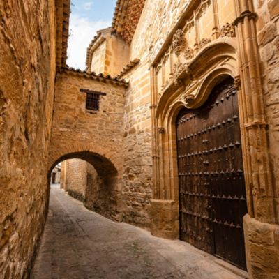 Fachada de casas medievales de piedra con grandes puertas de madera en el pueblo antiguo de Baeza