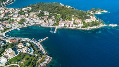 Sheltered Kassiopi Bay in Corfu, Greece, with Kassiopi Castle overlooking a harbour