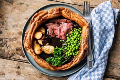 Überdimensionaler Yorkshire Pudding gefüllt mit Roastbeef, Broccoli, Erbsen und brauner Soße