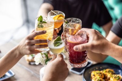 Revellers making a toast with various colourful cocktails