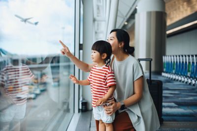 A parent and child at an airport ahead of a long-haul flight