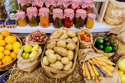 A vibrant display of jarred pickles and fresh produce at a farmers market