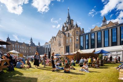 Sonniger Tag auf dem Edinburgh International Book Festival mit Menschen auf einer Wiese vor Zelten
