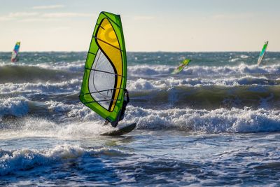 Windsurfer im französischen Mittelmeer an einem stürmischen Tag mit hohen Wellen