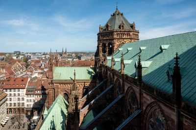 Catedral de Estrasburgo con tejado verde y torre tallada bajo un cielo azul despejado