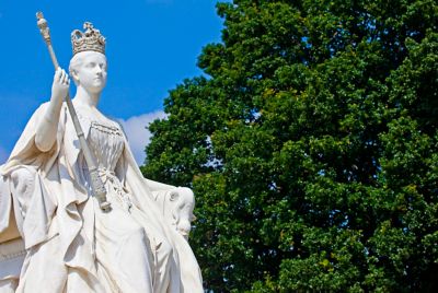 An elegant white statue of Queen Victoria outside Kensington Palace, London