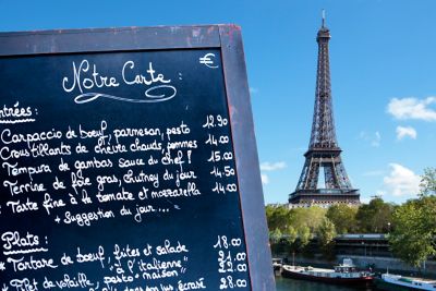 A chalkboard with a handwritten menu at a restaurant near the Eiffel Tower in Paris