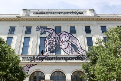 Fachada del Museo de Arte Contemporáneo de Lyon con un enorme mural de una figura humana