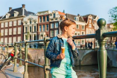 Fillette qui promène en mangeant une glace au-dessus d’un canal à Amsterdam