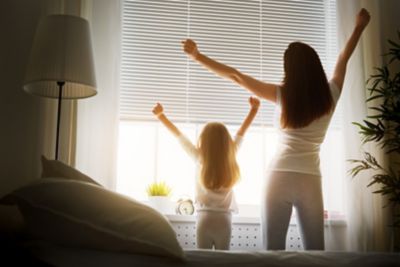 Une mère et sa fille qui s’étirent le matin, après avoir bien dormi grâce au respect du rythme circadien