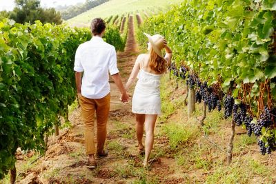 Un couple qui se promène dans un vignoble lors d’un week-end romantique en été