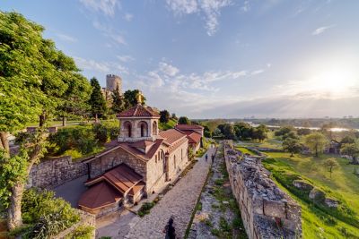 Belgrade Fortress amid leafy, peaceful Kalemegdan Park against a blue sky