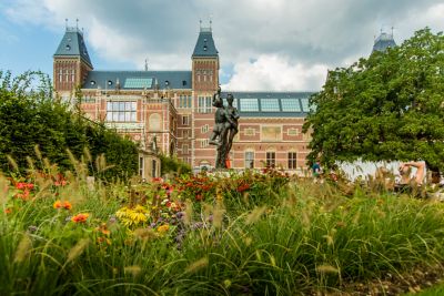 Garten des Rijksmuseums in Amsterdam an einem bewölkten Sommertag mit Wildblumen und Statuen