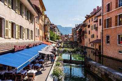 Outdoor tables under awning and umbrellas at restaurants in Annecy, France