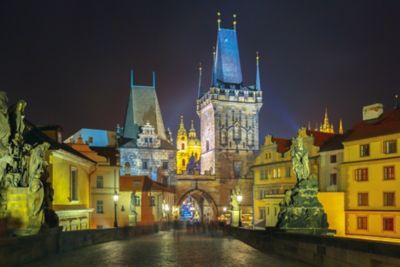 Shadowy figures on Prague's Charles Bridge at night