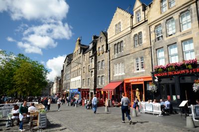 Calle concurrida con edificios de piedra y el pub Maggie Dickson's en Edimburgo