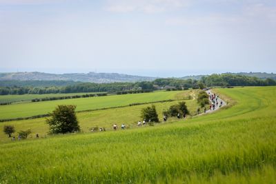 Cyclists on a road in Ditchling Beacon, South Downs, amid rolling countryside