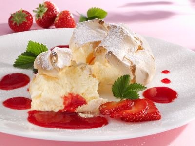 Salzburger Nockerl, eine Baiser-Spezialität aus Österreich, mit Erdbeersoße und frischen Erdbeeren