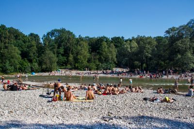 Menschen baden in und sonnen sich an der Isar in München im Sommer