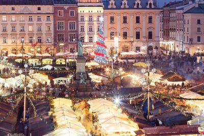Weihnachtsmarkt auf dem Marktplatz in der Altstadt von Krakau mit erleuchteten Buden