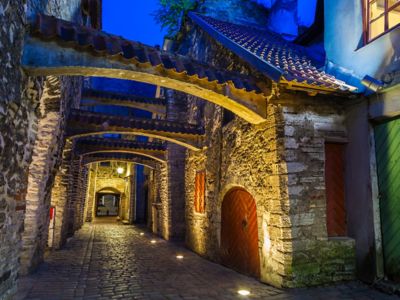 The stone walls and cobbled walkway of St. Catherine Passage, Tallinn, by night