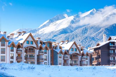 Wooden chalets amid a snowy mountain landscape in Bansko ski resort, Bulgaria