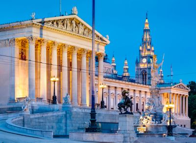 Parlement d'Autriche et les tours de l’hôtel de ville en arrière-plan, à la tombée de la nuit