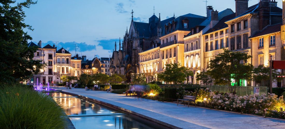 Evening Promenade in Troyes, France: Canal Lit by Illuminated Buildings