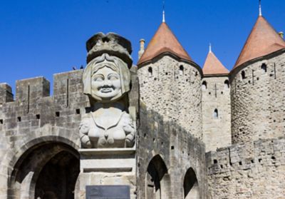 The enormous stone sculpture of Lady Carcas backed by Carcassonne's turrets