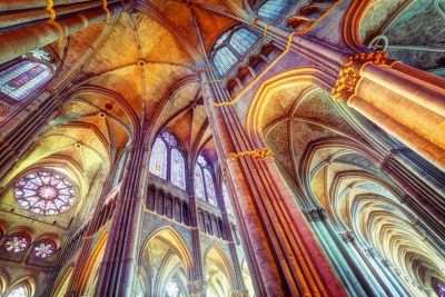 Murs en pierre colorés par la lumière filtrant à travers les vitraux de la cathédrale Notre-Dame de Reims