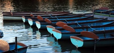 Blue rowing boats moored at a pier in Windsor on the River Thames, England