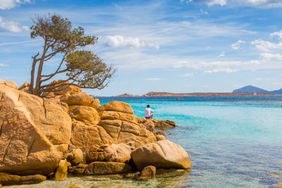 Homme qui admire la mer depuis une plage, lors d’un week-end en Sardaigne