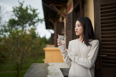 A traveller drinking water, recommended as part of a healthy morning travel routine