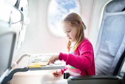 A child playing a travel game while seated in an airplane