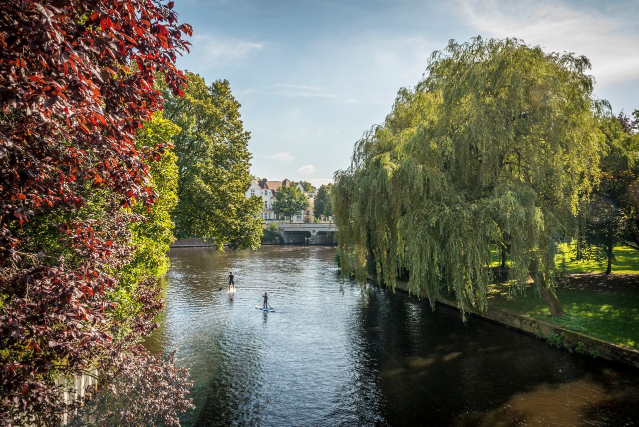 Stand-up-Paddler im von Bäumen gesäumten Isebekkanal im Hamburger Stadtteil Eppendorf