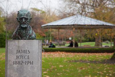 Busto de bronce de James Joyce sobre un pedestal de piedra en un parque