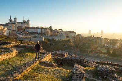 A man gazing at the ruins of the Fourvière Roman Theatres in Lyon at sunrise