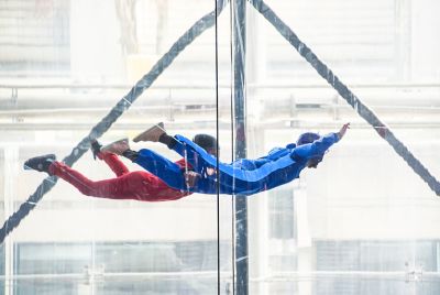 An adventurous pair of skydivers floating in an indoor wind tunnel