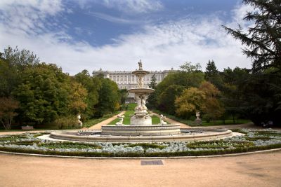 Fachada oeste del Palacio Real al fondo, con una fuente y árboles de los jardines del Campo del Moro