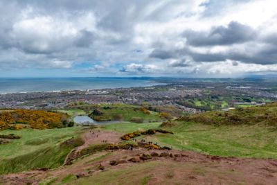 Die Dächer von Edinburgh an der wolkenverhangenen Küste, gesehen vom Arthur's Seat im Holyrood Park