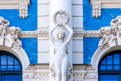 Blau-weiße Fassade des Jugendstilgebäudes mit Frauenstatue in der Strēlnieku iela Nr. 4a in Riga