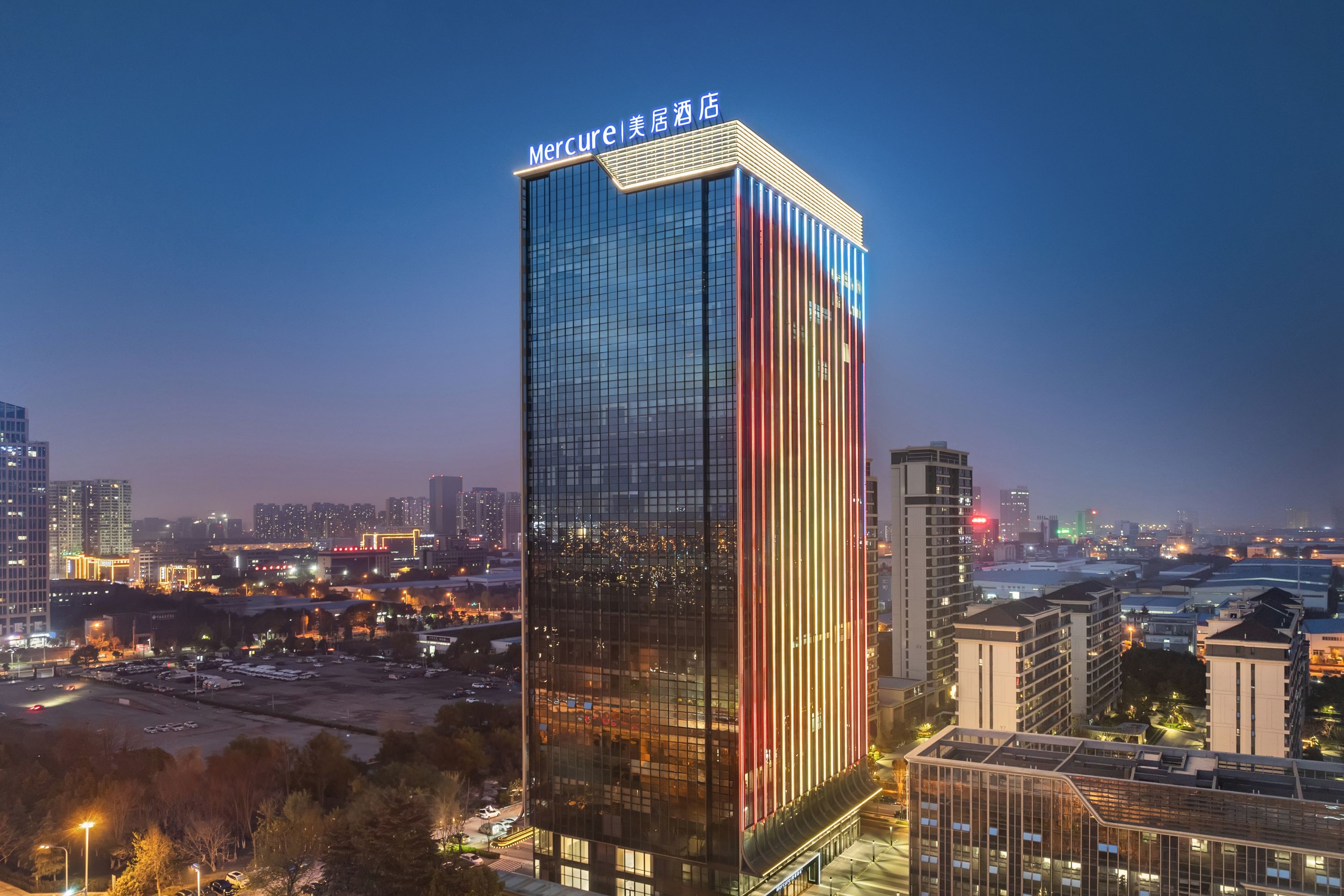 Mercure Hotel Illuminated Against Twilight Cityscape