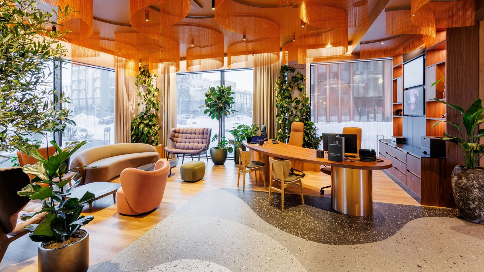 Lobby des Novotel Tallinn, mit Grünpflanzen und gemütlichen Sofas und Sesseln in Orangetönen