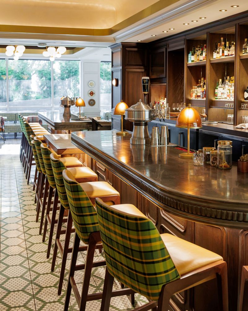 A bar with green plaid bar chairs