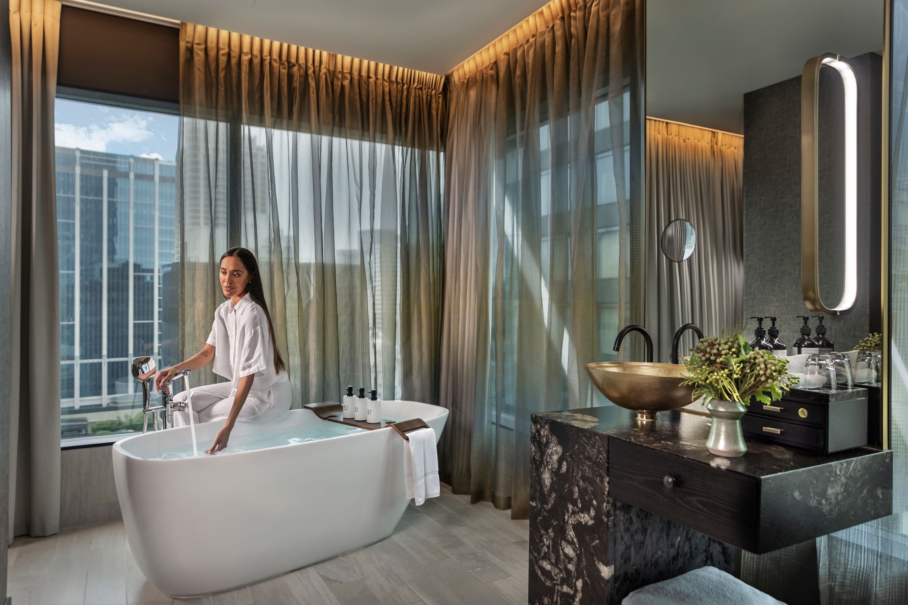 Woman Preparing a Bath in a Luxurious Hotel Suite